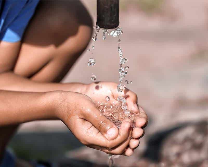 child cupping hands water