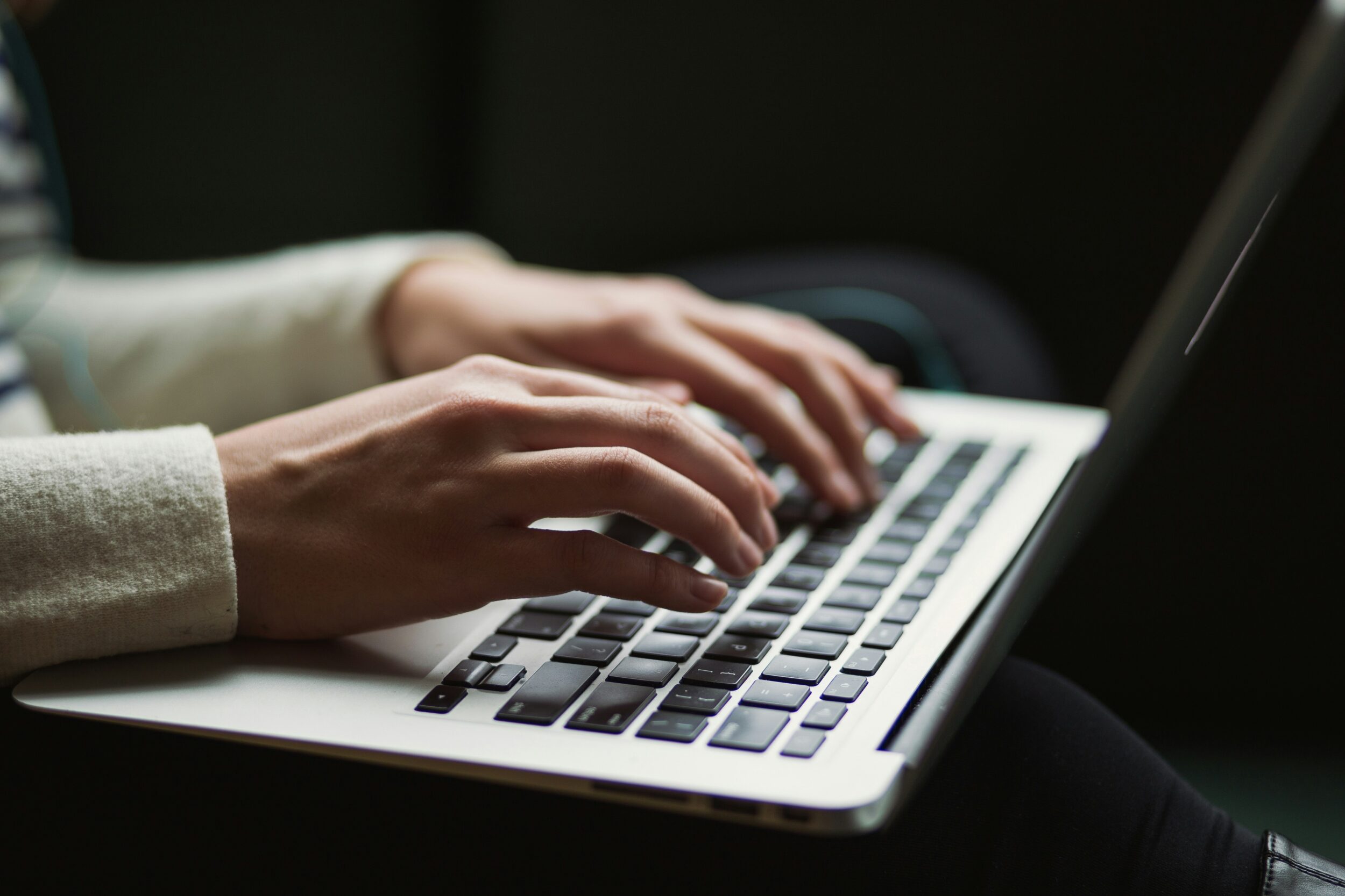 Hands typing on a computer.